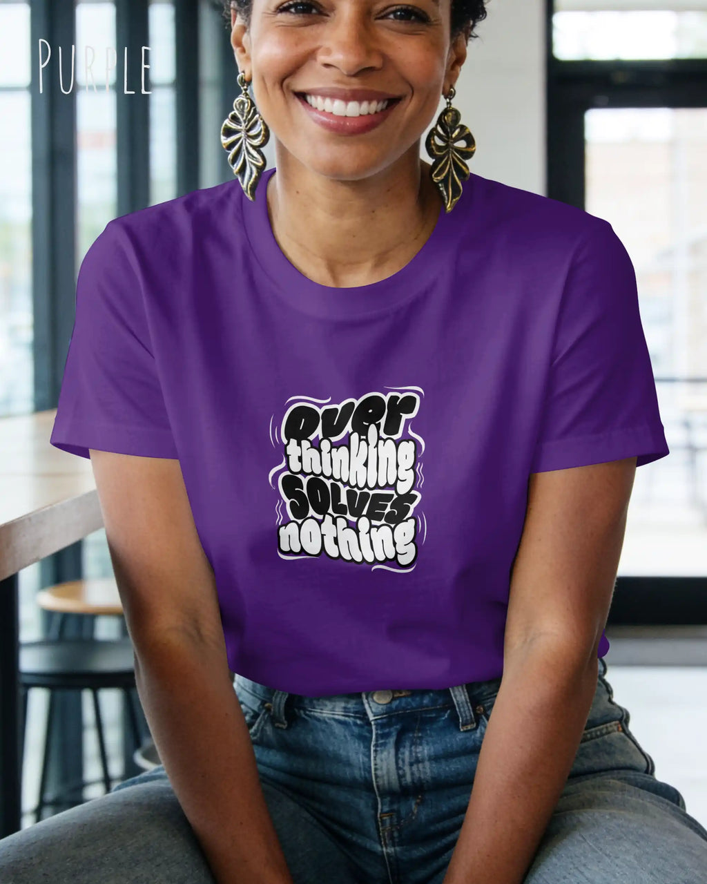 frau trögt ein design.t-shirt in purple mit dem motiv overthinking solves nothing.