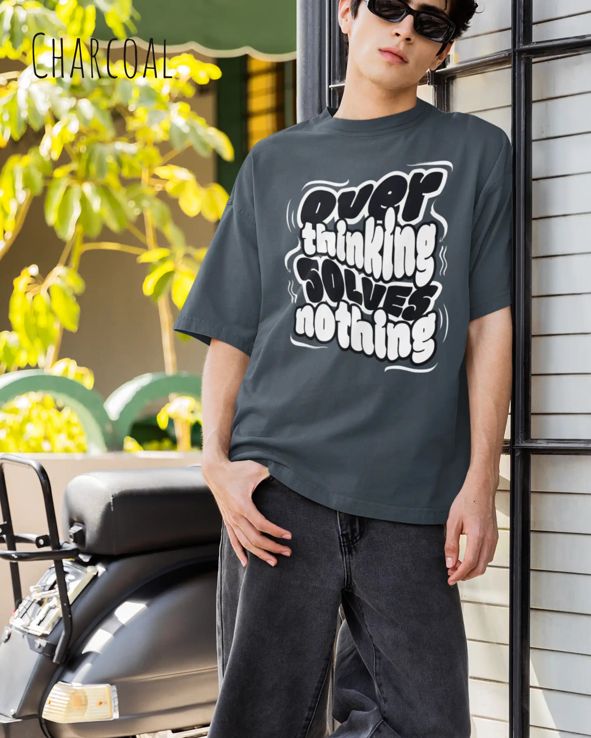 mann trägtt ein oversized heavyweight t-shirt in  charcoal mit dem design overthinking solves nothing.