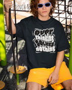 ein mann trägtt ein oversized heavyweight t-shirt in  new French navy mit dem design overthinking solves nothing.