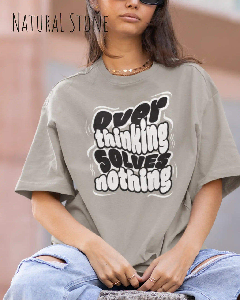 junge nfrau trägtt ein oversized heavyweight t-shirt in  natural stone mit dem design overthinking solves nothing.