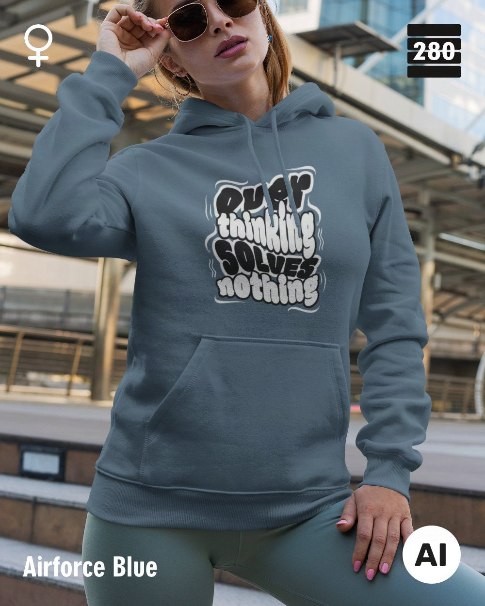 das bild zeigt eine frau, die einen leicht taillierten statement hoodie in der farbe airforce blue und mit dem motiv "overthinking solves nothing" trägt.