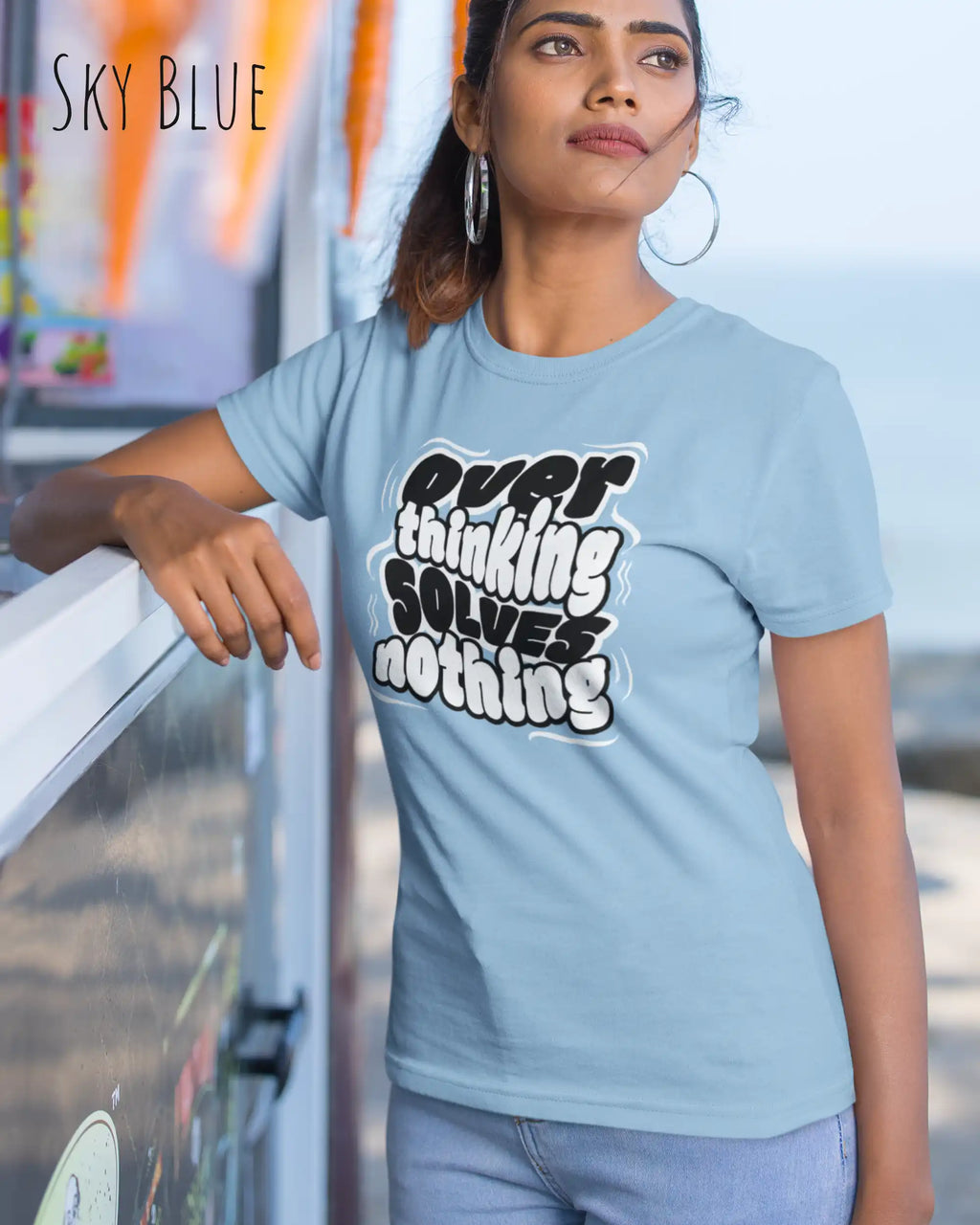 die Abbildung zeigt eine  frau, die ein damen design-t-shirt in der farbe sky blue mit dem Motiv "overthinking solves nothing" trägt,