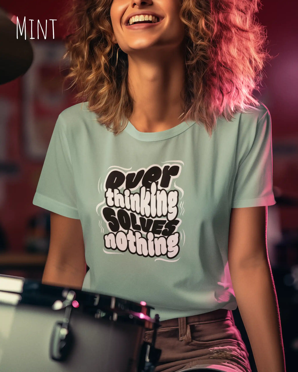 lachende frau trägt ein design t-shirt in der farbe mint mit dem motiv overthinking solves nothing.