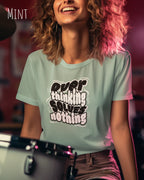 lachende frau trägt ein design t-shirt in der farbe mint mit dem motiv overthinking solves nothing.
