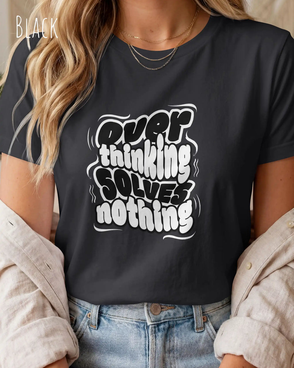diese Abbildung zeigt eine frau, die ein feminines design-t-shirt in der farbe black mit dem ausdrucksstarken design "overthinking solves nothing" trägt.