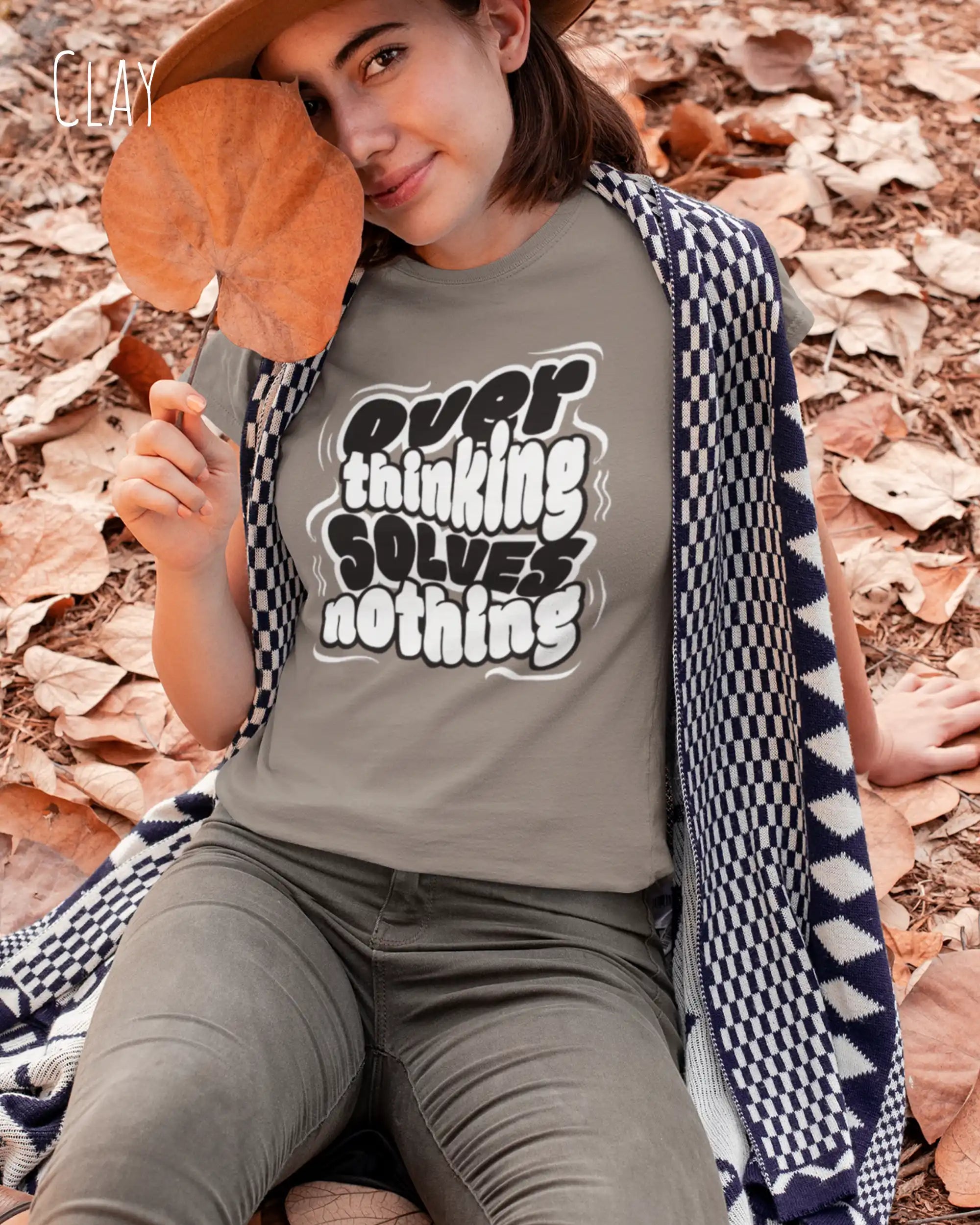 diese Abbildung zeigt eine frau, die ein feminines design-t-shirt in der farbe clay mit dem ausdrucksstarken design "overthinking solves nothing" trägt.