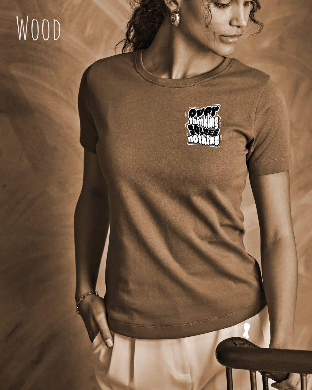 diese Abbildung zeigt eine frau, die ein feminines design-t-shirt in der farbe wood mit dem ausdrucksstarken design "overthinking solves nothing" oben links trägt.