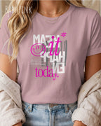 eine frau trägt ein unisex design t-shirt  in baby pink mit dem motiv make it happen today.
