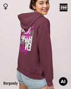 das bild zeigt eine frau, die einen leicht taillierten damen hoodie in der farbe burgundy und mit dem statement design "make it happen today" auf dem rücken trägt.
