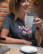 frau im cafe trägt ein design t-shirt in der farbe navy mit dem motiv make it happen today.
