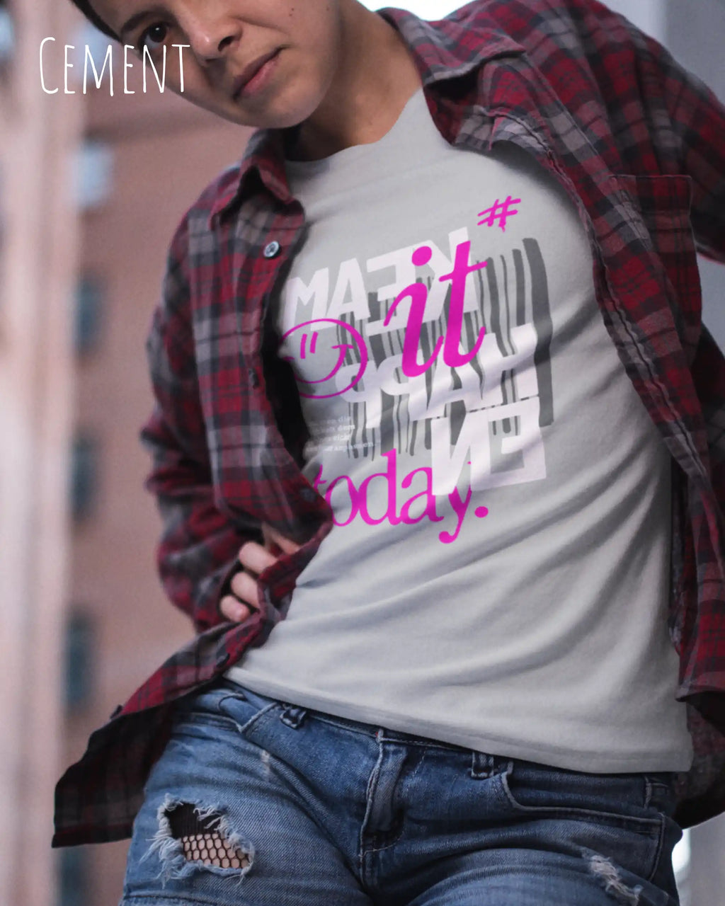das bild zeigt eine coole junge frau, die ein feminines design-t-shirt in der farbe cement mit dem inspirierenden motiv "make it happen today" trägt,