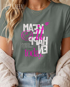 das bild zeigt eine frau, die ein feminines design-t-shirt in der farbe leaf green mit dem inspirierenden motiv "make it happen today" trägt,