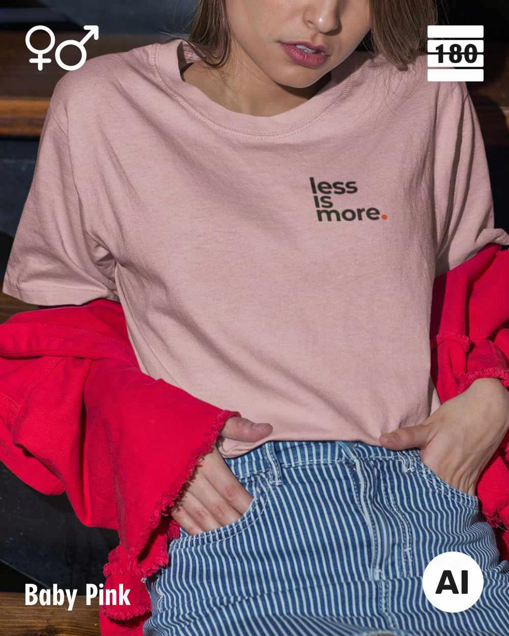 Das bild zeigt eine frau, die ein Unisex Design-T-Shirt in der farbe baby pink mit dem minimalistischen motiv "less is more" trägt.