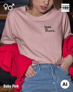 Das bild zeigt eine frau, die ein Unisex Design-T-Shirt in der farbe baby pink mit dem minimalistischen motiv "less is more" trägt.