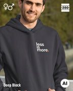 das bild zeigt eine person, die einen unisex design hoodie in der farbe deep black und mit dem minimalistischen motiv "less is more" trägt.