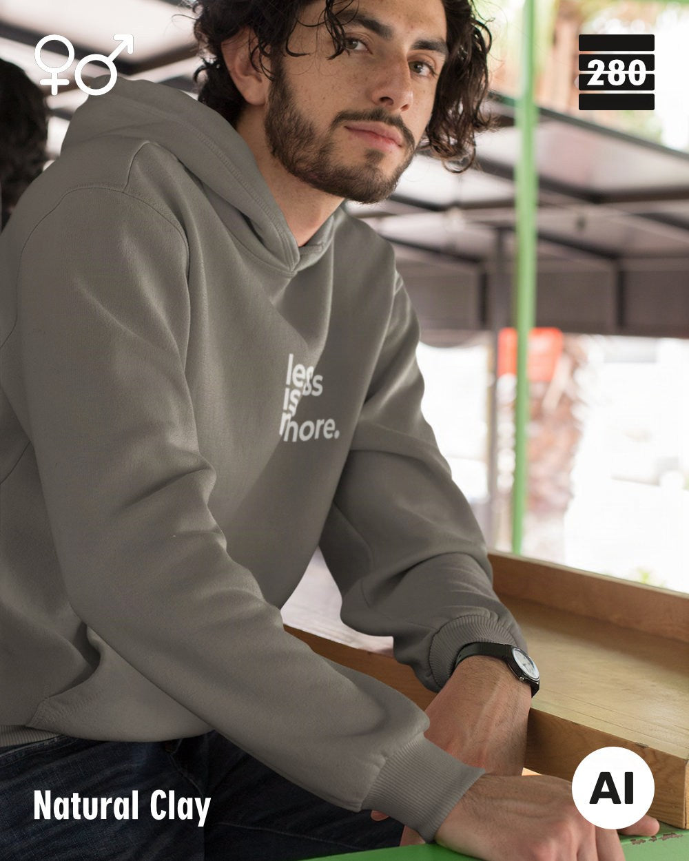 das bild zeigt eine person, die einen unisex design hoodie in der farbe natural clay und mit dem minimalistischen motiv "less is more" trägt.