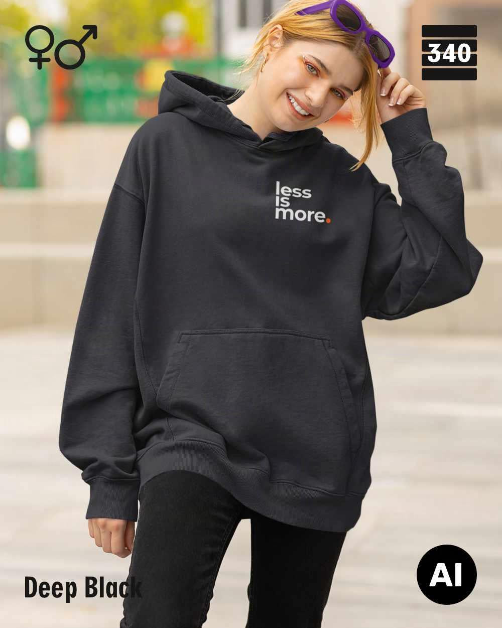 hier siehst man eine person, die einen Oversized Design-Hoodie unisex in der farbe deep black mit dem minimalistischen motiv "less is more" trägt.