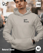 hier siehst man eine person, die einen Oversized Design-Hoodie unisex in der farbe natural stone  mit dem minimalistischen motiv "less is more" trägt.