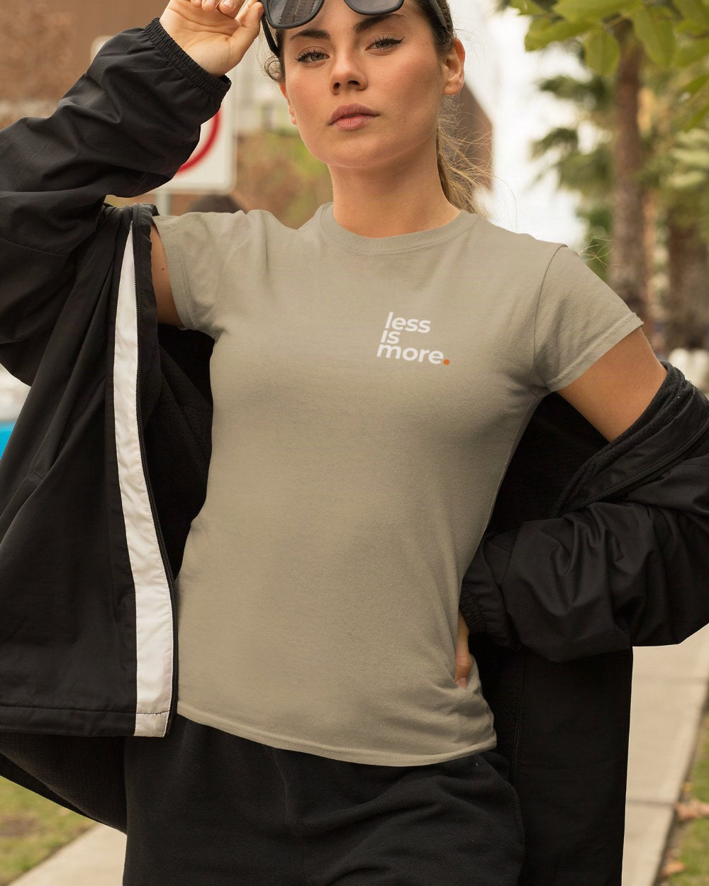 Eine Frau trägt ein figurbetontes Damen T-Shirt in der Farbe khaki mit dem minimalistischen Design "less is more" oben links.