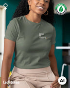 auf diesem bild sieht man eine frau, die ein nachhaltiges Damen-T-Shirt  in der Farbe leaf green mit dem minimalistischen Design "less is more" trägt.
