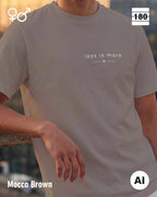 Diese abbildung zeigt eine Person, die ein Unisex Design-T-Shirt in der farbe mocca brown mit dem zeitlosen motiv "less is more" trägt.