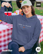 das bild zeigt eine frau, die einen unisex design hoodie in der farbe denim blue und mit dem zeitlosen motiv "less is more" trägt.