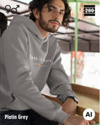 das bild zeigt eine person, die einen unisex design hoodie in der farbe platin grey und mit dem zeitlosen motiv "less is more" trägt.