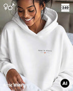 Eine frau trägt einen Oversized Design-Hoodie unisex in der farbe arctic white  mit dem zeitlosen statement "less is more" oben links.
