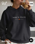 Eine frau trägt einen Oversized Design-Hoodie unisex in der farbe deep black  mit dem zeitlosen statement "less is more" vorne auf der brust.