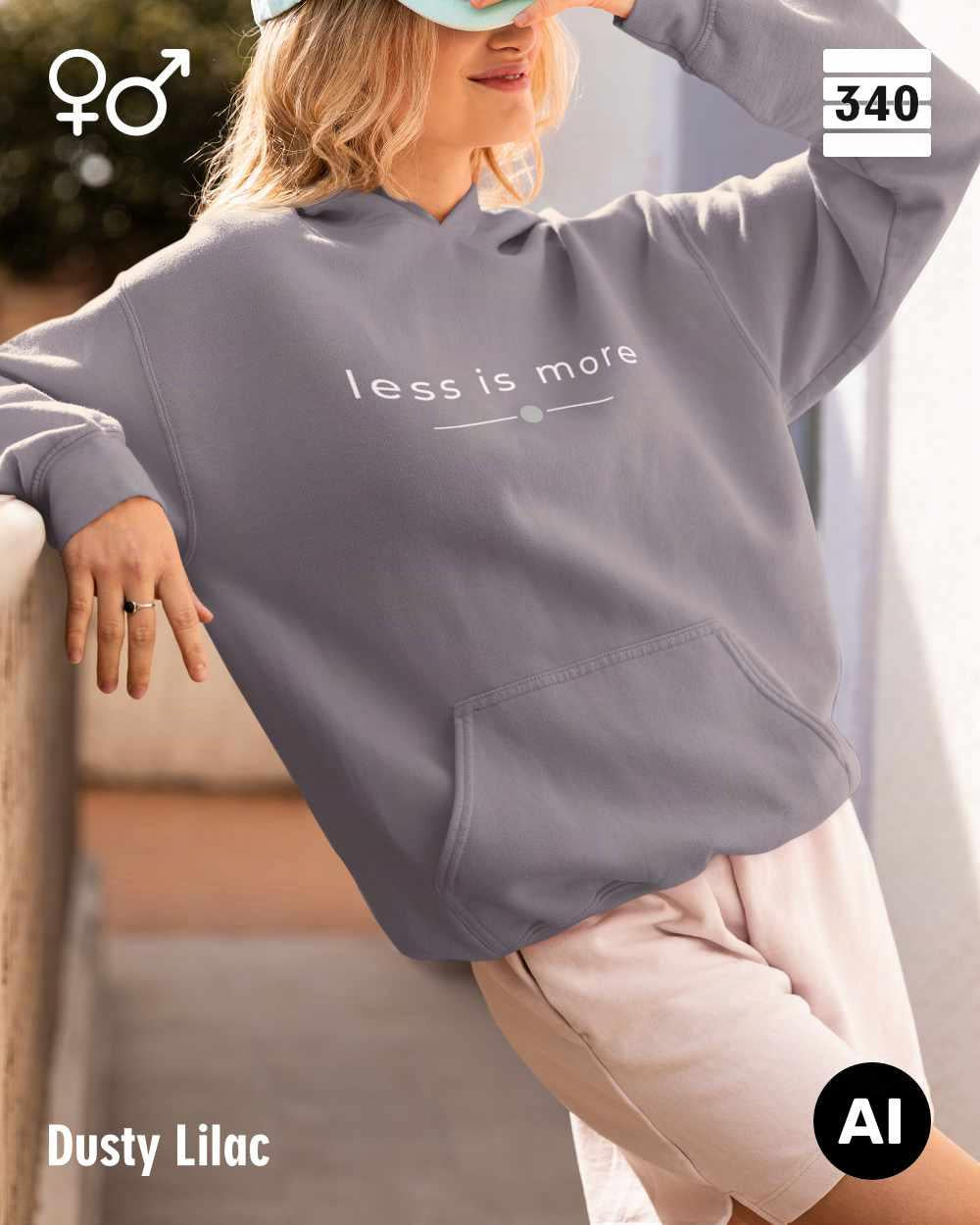 Eine blonde  frau trägt einen Oversized Design-Hoodie unisex in der farbe dusty lilac  mit dem zeitlosen statement "less is more" vorne mittigauf der brust.