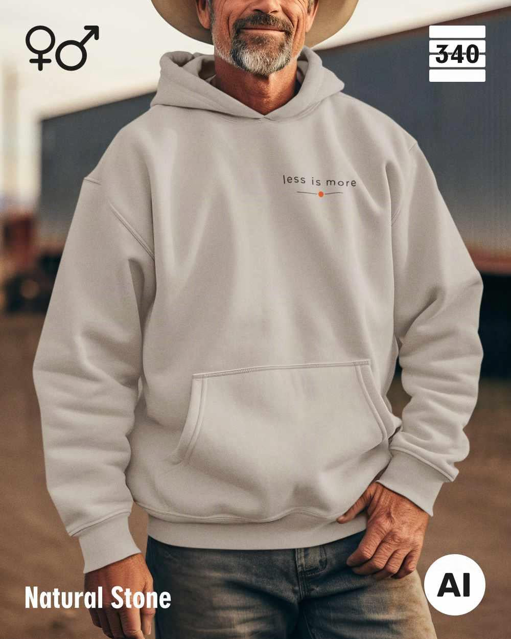 Ein mann trägt einen Oversized Design-Hoodie unisex in der farbe natural stone  mit dem zeitlosen  statement "less is more" oben links.