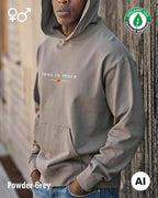 ein mann trägt einen Premium Design-Hoodie aus 100% Bio-Baumwolle in der farbe powder grey mit dem eleganten motiv "less is more" mittig auf der brust..