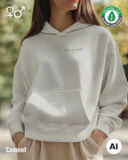 eine selbstbewusste frau trägt einen Premium Design-Hoodie aus 100% Bio-Baumwolle in der farbe cement mit dem eleganten motiv "less is more" oben links.
