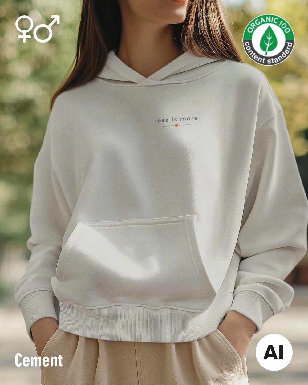 eine selbstbewusste frau trägt einen Premium Design-Hoodie aus 100% Bio-Baumwolle in der farbe cement mit dem eleganten motiv "less is more" oben links.
