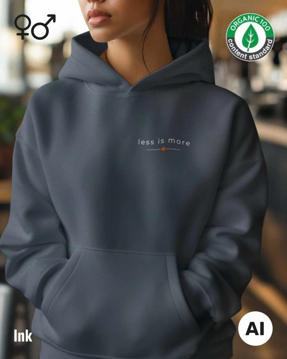 eine frau trägt einen Premium Design-Hoodie aus 100% Bio-Baumwolle in der farbe ink mit dem eleganten motiv "less is more" oben links.