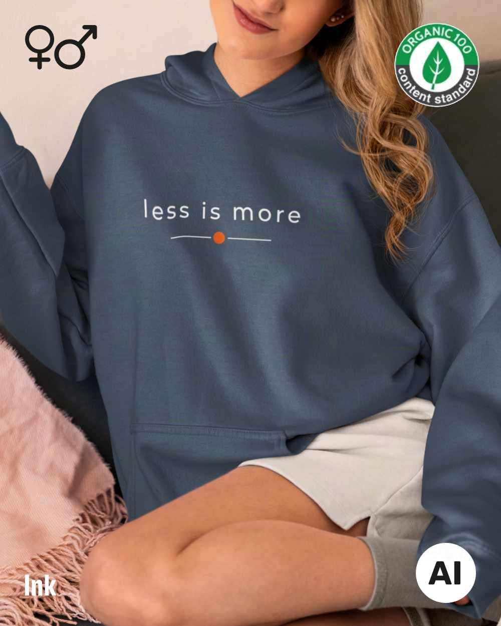 eine frau trägt einen Premium Design-Hoodie aus 100% Bio-Baumwolle in der farbe ink mit dem eleganten motiv "less is more" .