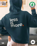 die ki-generierte Abbildung zeigt eine frau, die einen oversized Premium Design-Hoodie in der farbe ink mit dem minimalistischen motiv "less is more" auf dem rücken trägt.