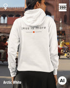 das bild zeigt eine frau, die einen leicht taillierten damen hoodie in der farbe arctic white und mit dem zeitlosen design "less is more" auf dem rücken trägt.