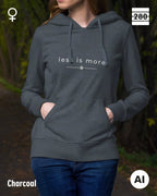 das bild zeigt eine frau, die einen leicht taillierten damen hoodie in der farbe charcoal und mit dem zeitlosen design "less is more" trägt.