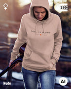 das bild zeigt eine frau, die einen leicht taillierten damen hoodie in der farbe nude und mit dem zeitlosen design "less is more" trägt.