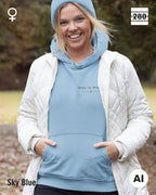 das bild zeigt eine blonde frau, die einen damen hoodie in der farbe sky blue und mit dem zeitlosen design "less is more" trägt.