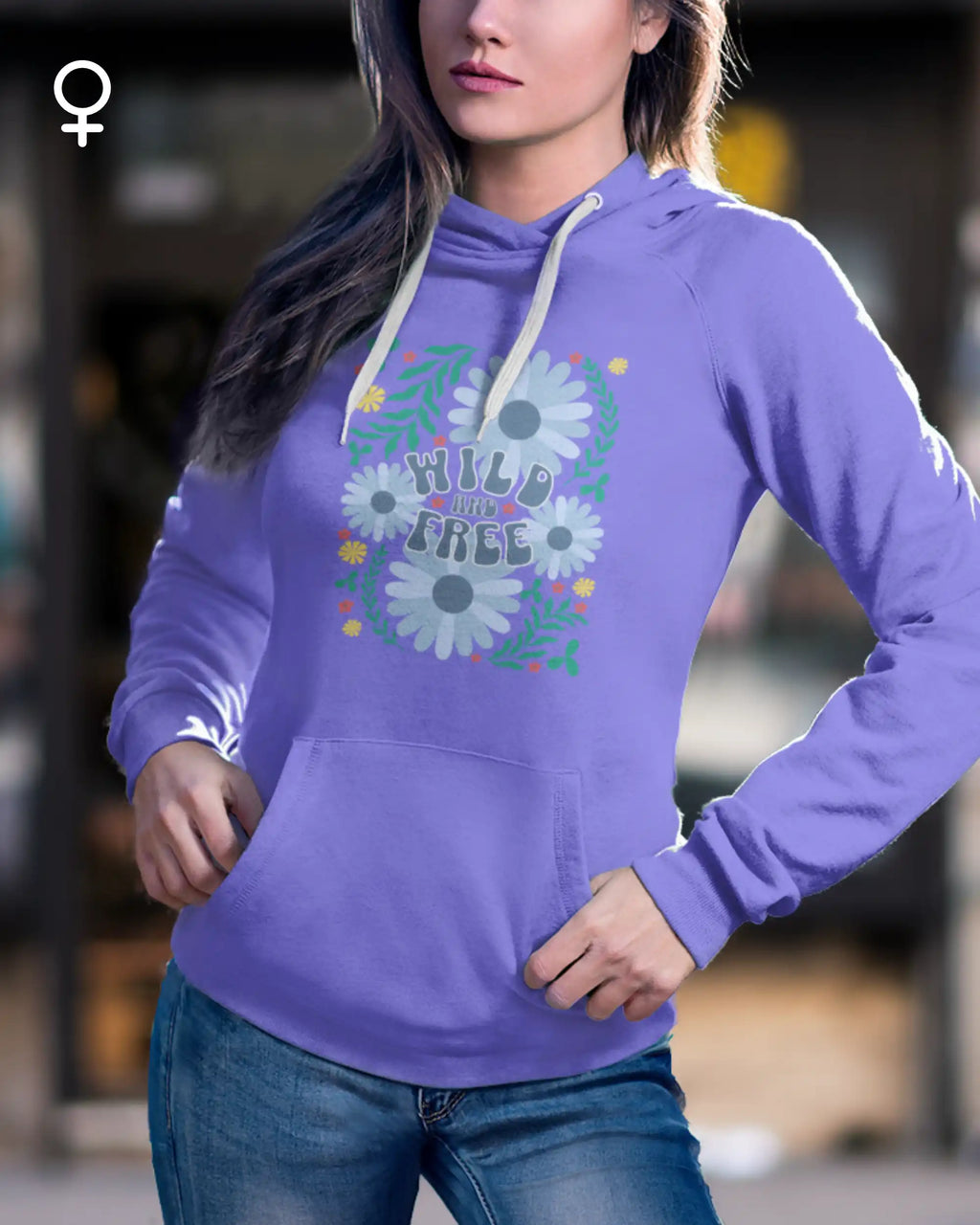 Eine Frau trägt einen femininen  Design-hoodie mit der Grafik wild and free.
