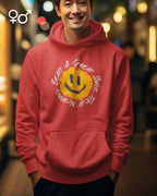 Eine lachender mann trägt einen unisex oversized  design-hoodie mit einem fröhlichen smiley-motiv.