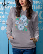 Eine Frau trägt einen unisex design-hoodie mit der Grafik wild and free.