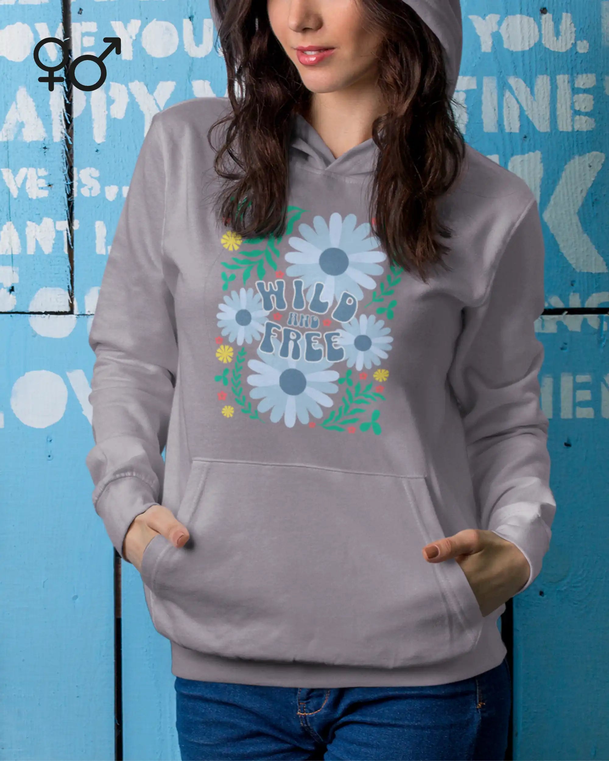Eine Frau trägt einen unisex design-hoodie mit der Grafik wild and free.