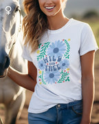 Eine Frau trägt ein feminines  Design-T-Shirt mit der Grafik wild and free.